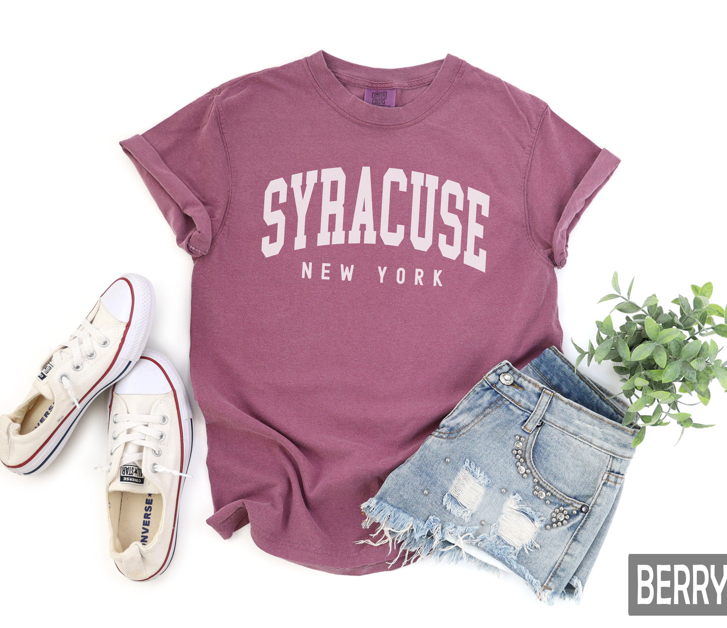 a t - shirt that says syracuse new york next to a pair of