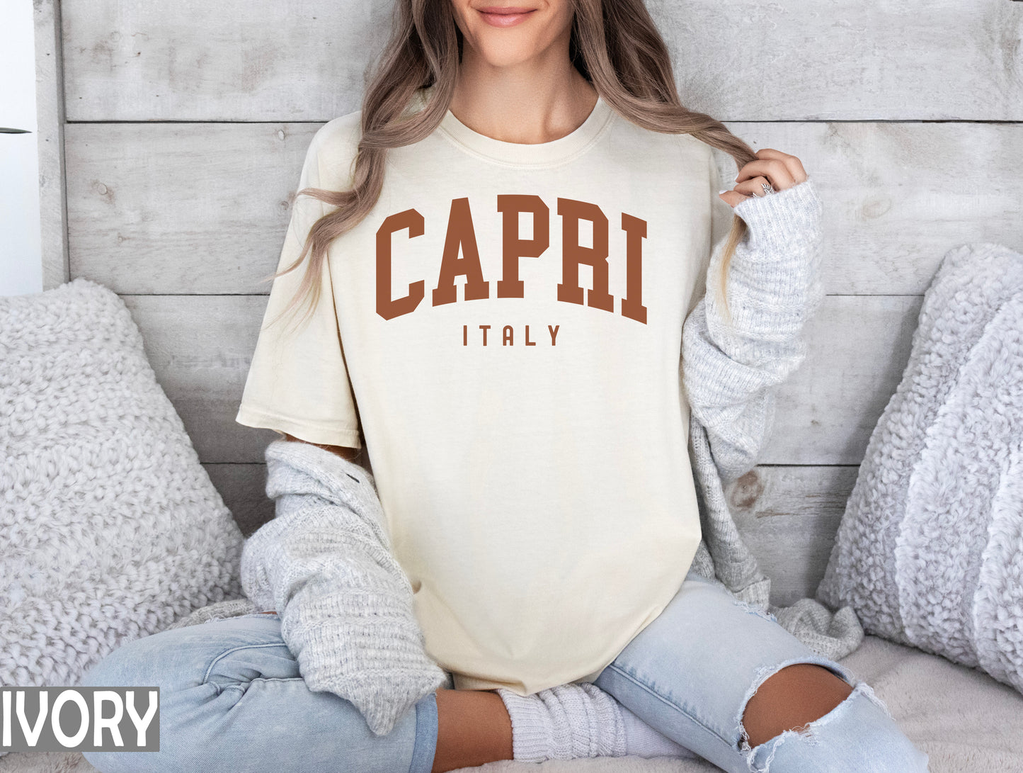 a woman sitting on a bed wearing a capri t - shirt