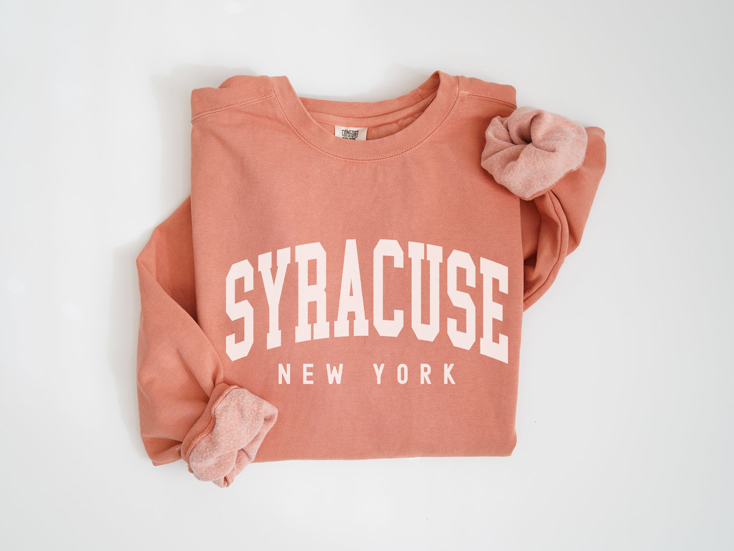 a pink sweatshirt with a bow on the back of it