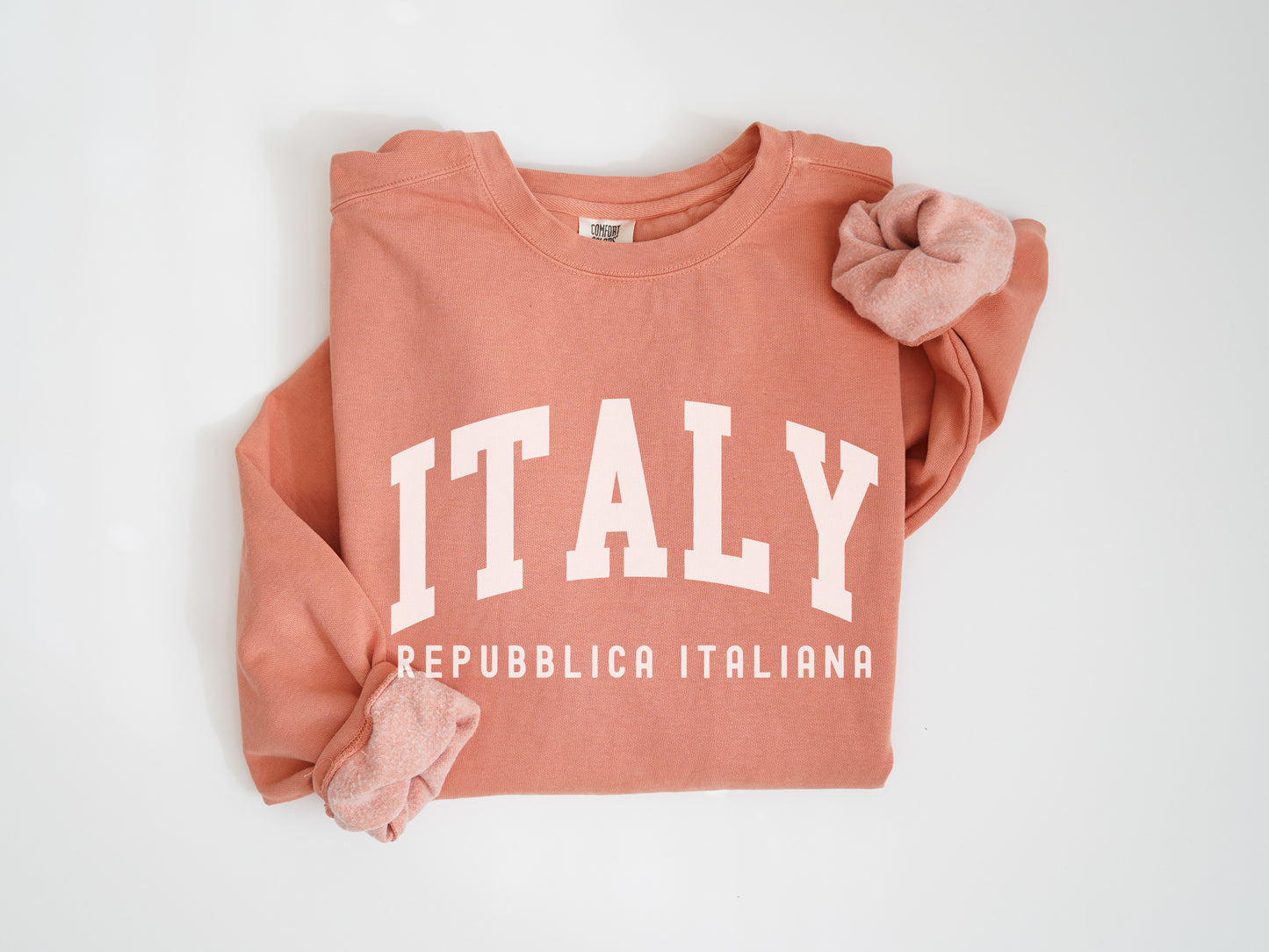 a pink sweatshirt with the word italy printed on it