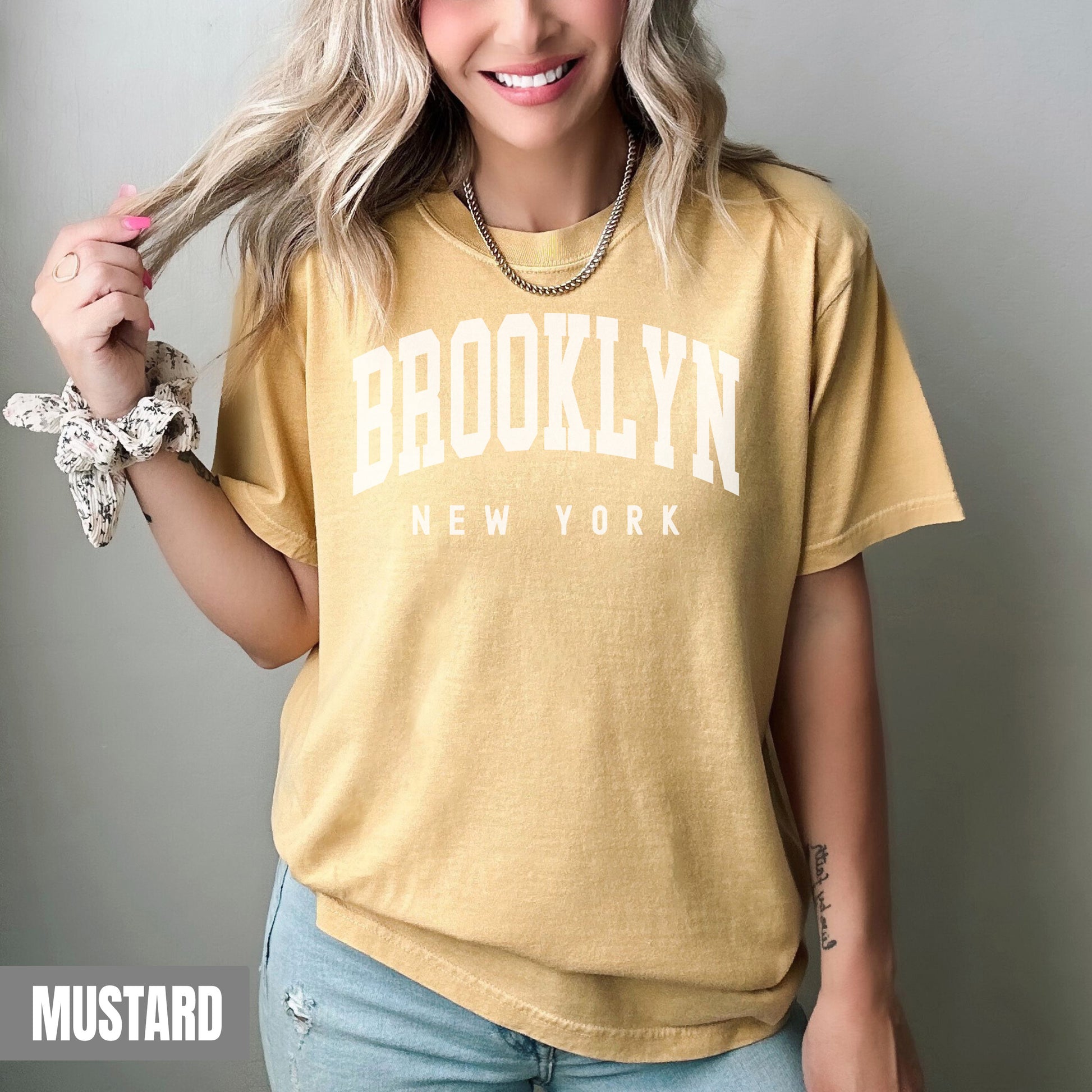 a woman with blonde hair wearing a brooklyn t - shirt