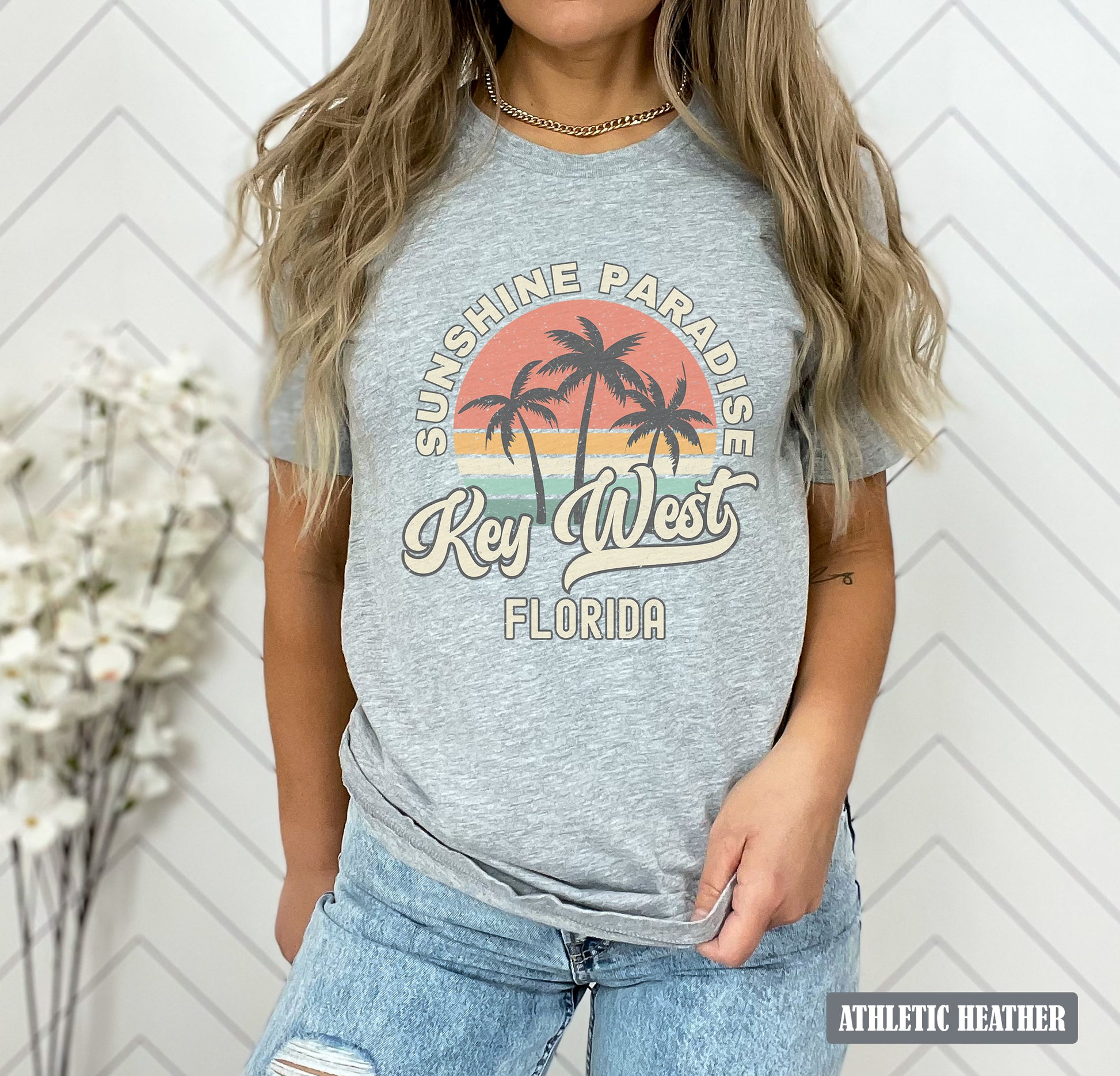 a woman wearing a grey shirt with a palm tree on it