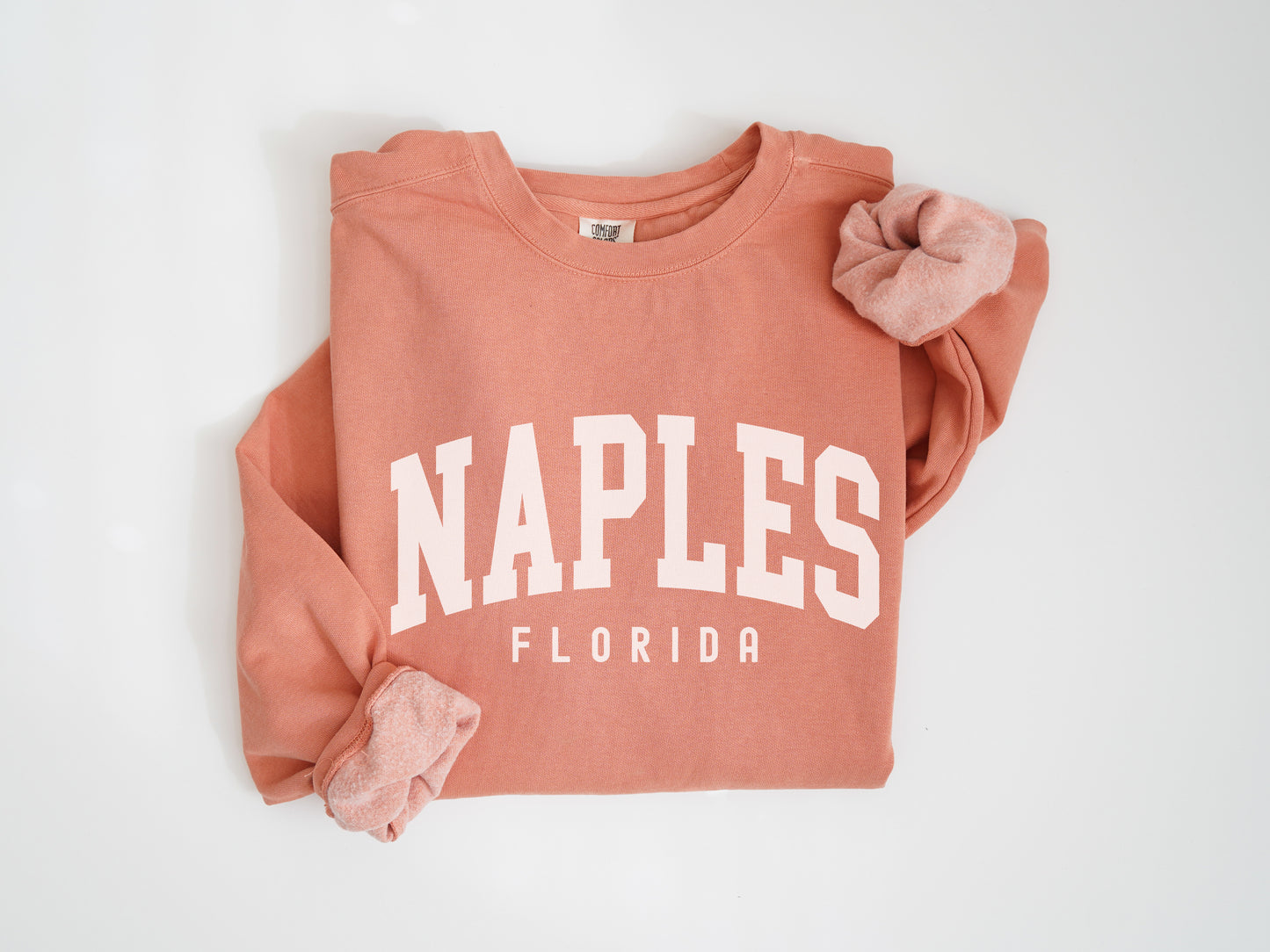 a pink sweatshirt with the word naples on it