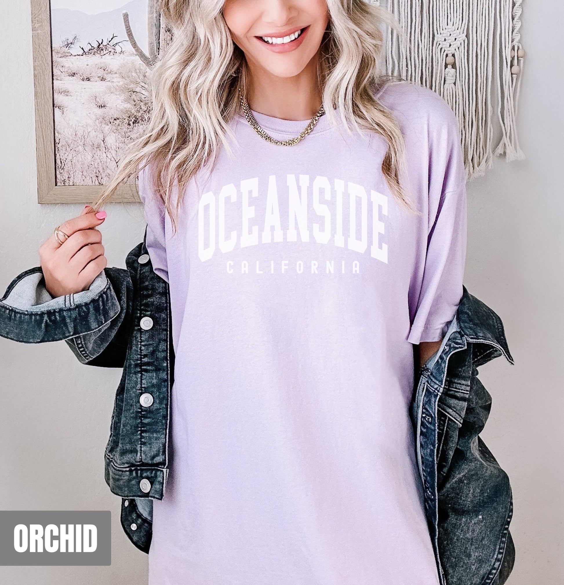 a woman with blonde hair wearing a purple oceanside shirt