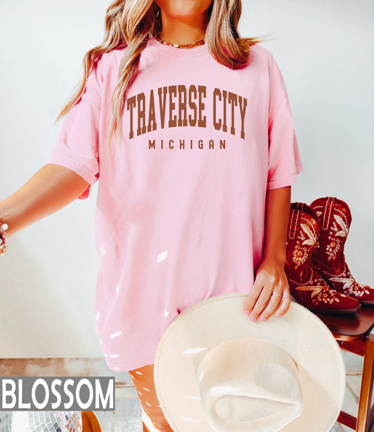 a woman wearing a pink traverse city michigan shirt