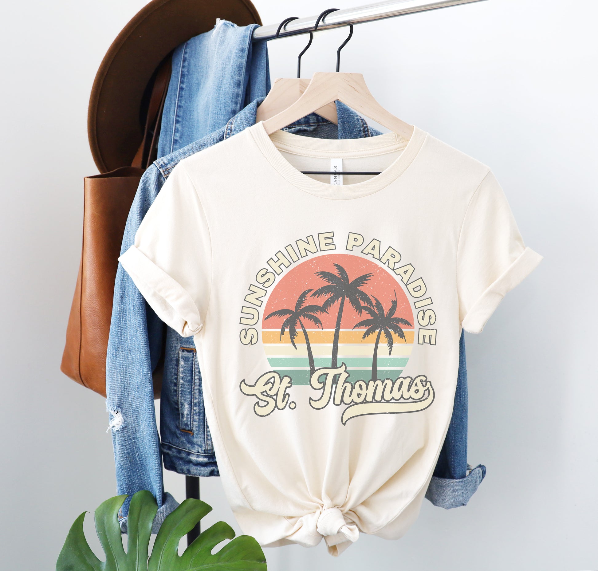 a t - shirt with a palm tree on it hanging on a rack