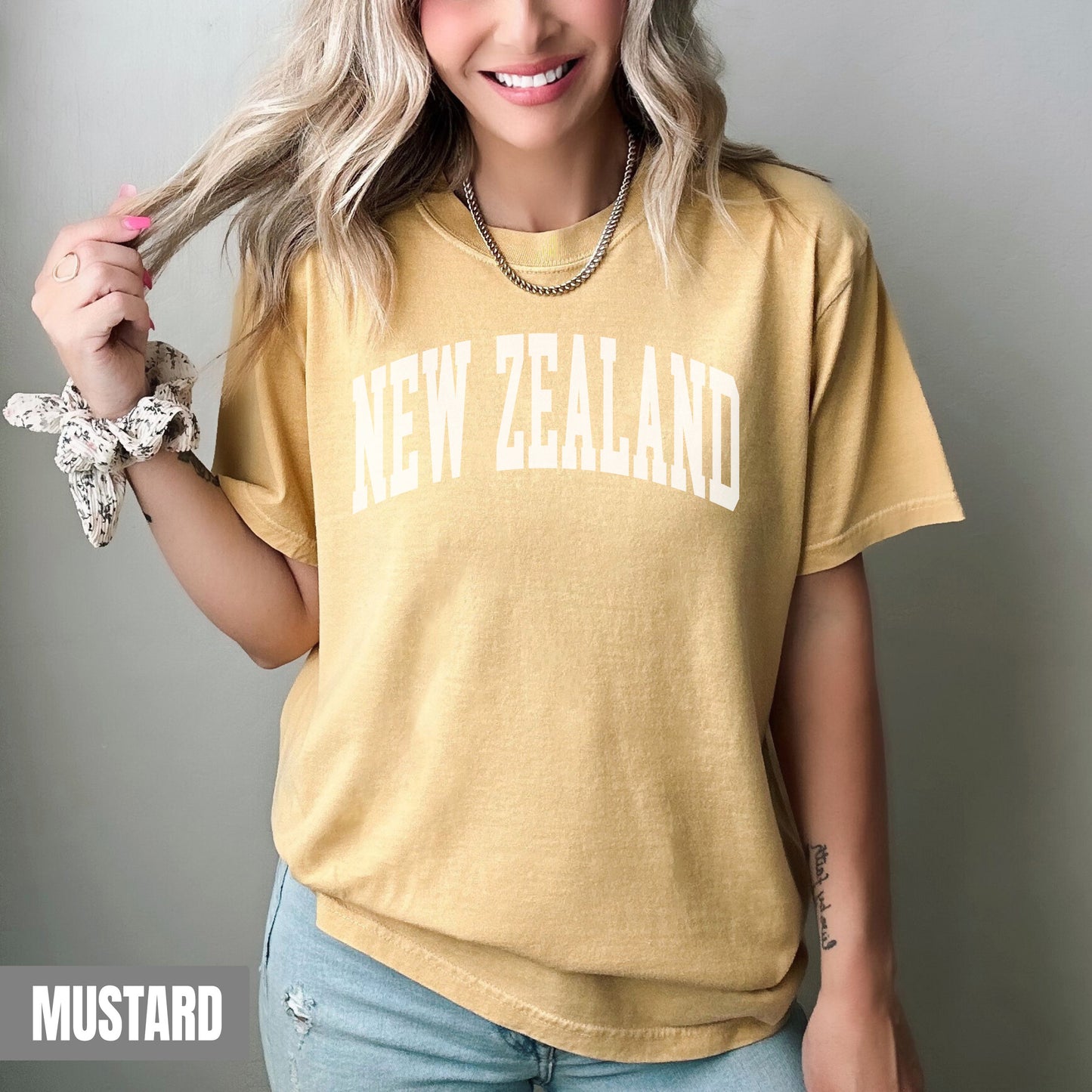 a woman with blonde hair wearing a new zealand t - shirt