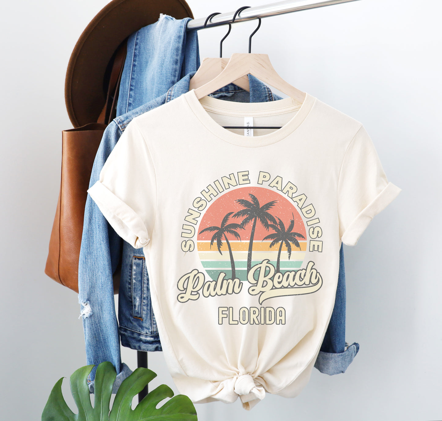 a white shirt with palm trees on it hanging on a rack