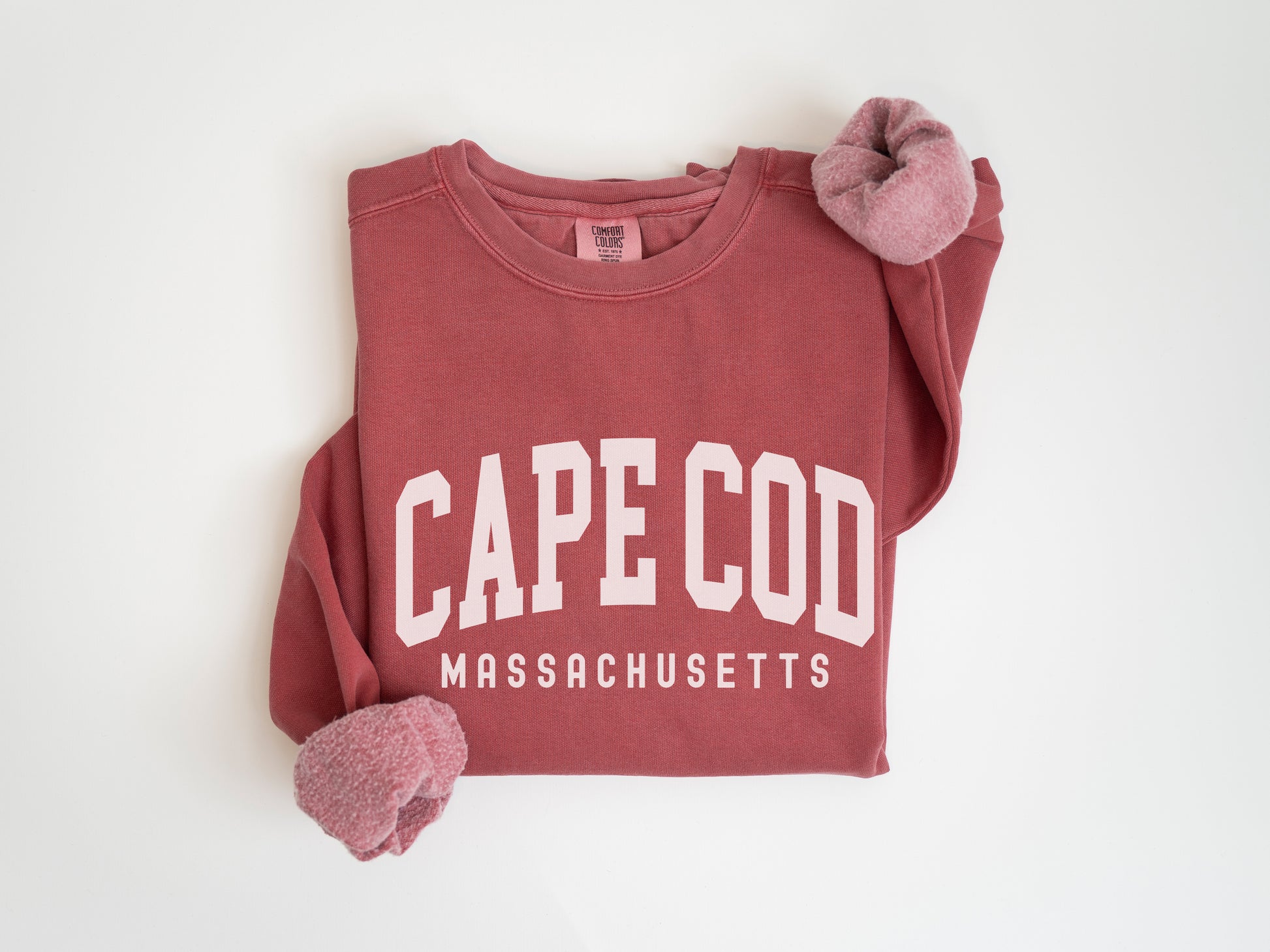 a red cape co sweatshirt with a pink pom pom