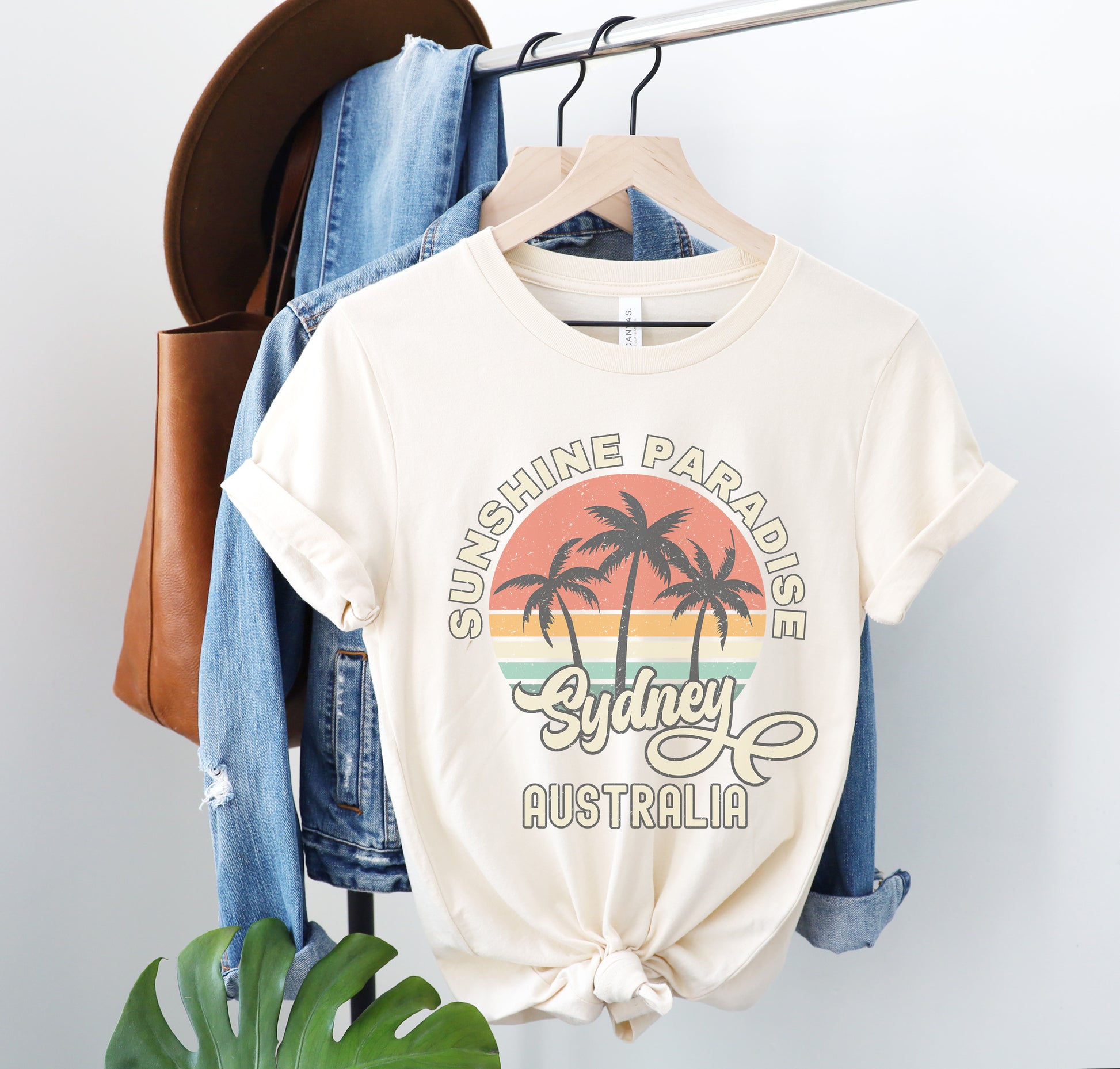 a t - shirt that says sunshine paradise sydney australia hanging on a rack