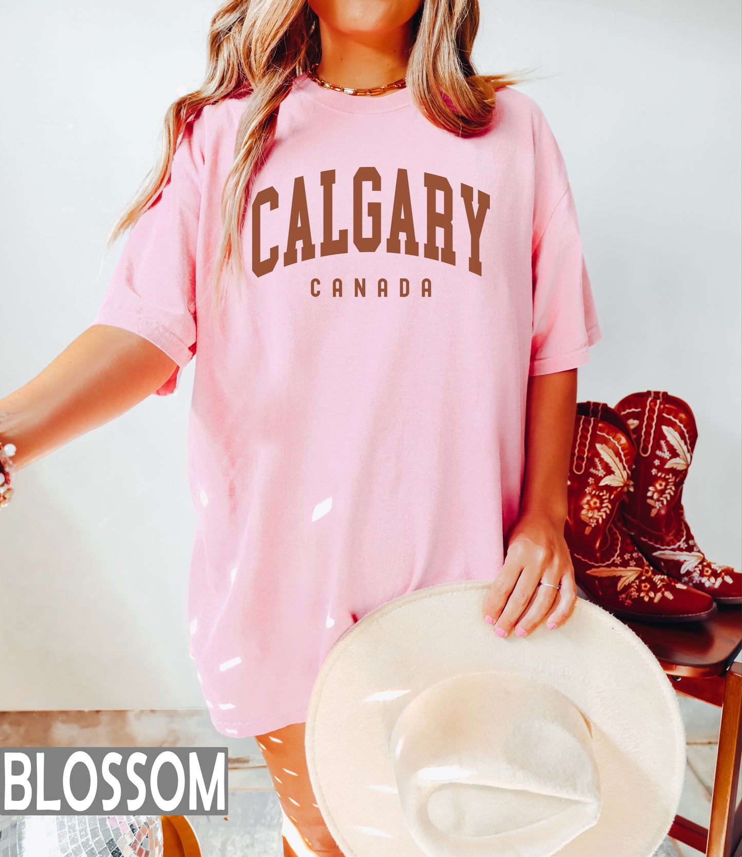 a woman wearing a pink shirt and cowboy boots