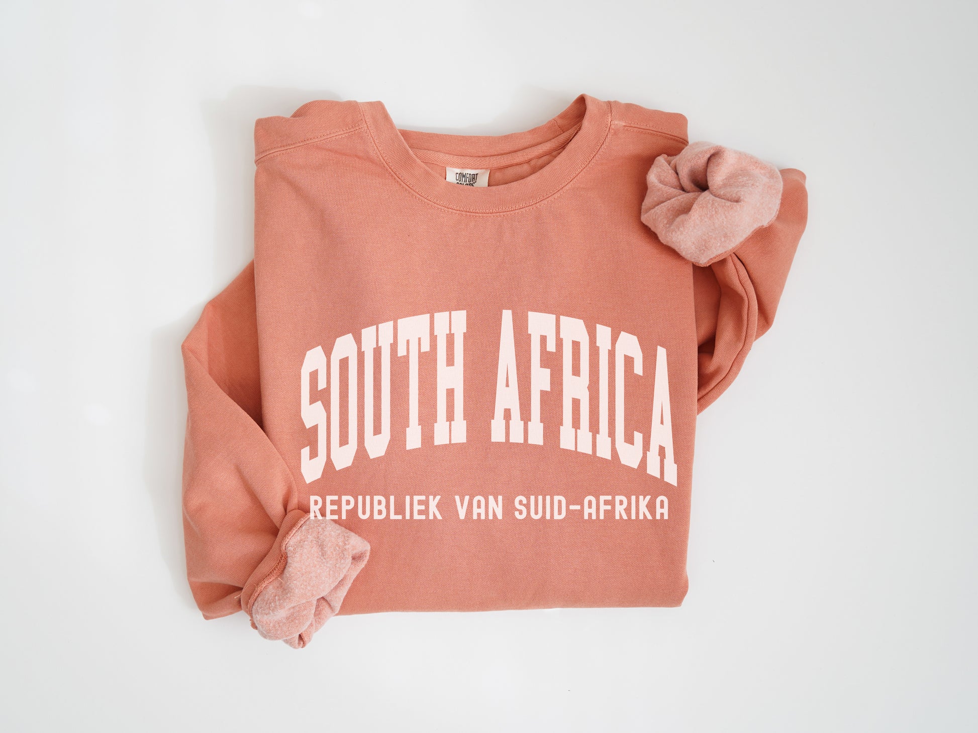 a pink sweatshirt with white south africa on it