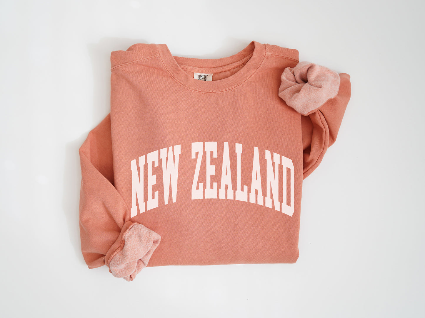 a pink sweatshirt with a pink bow on the front