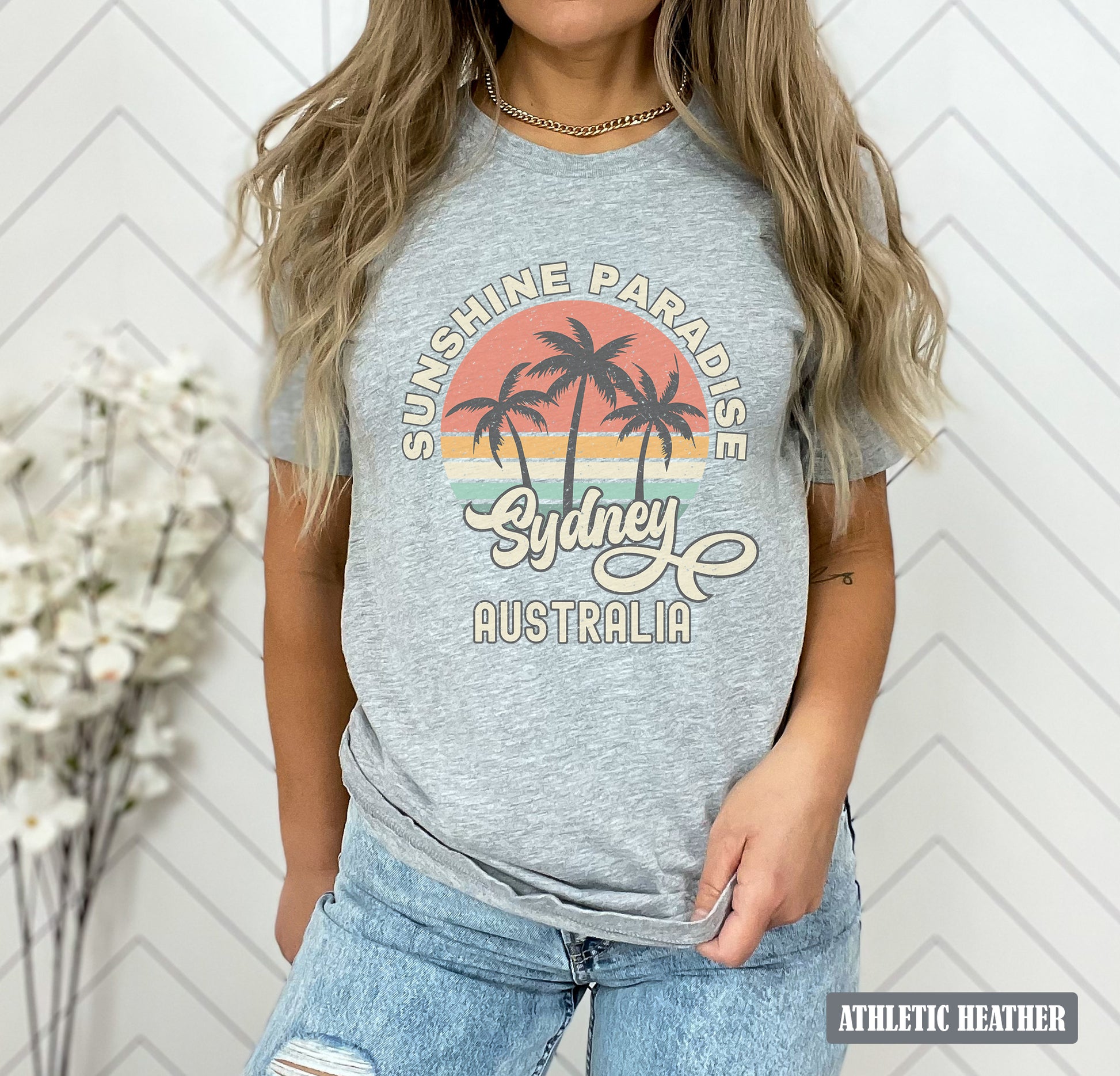 a woman wearing a grey shirt with palm trees on it