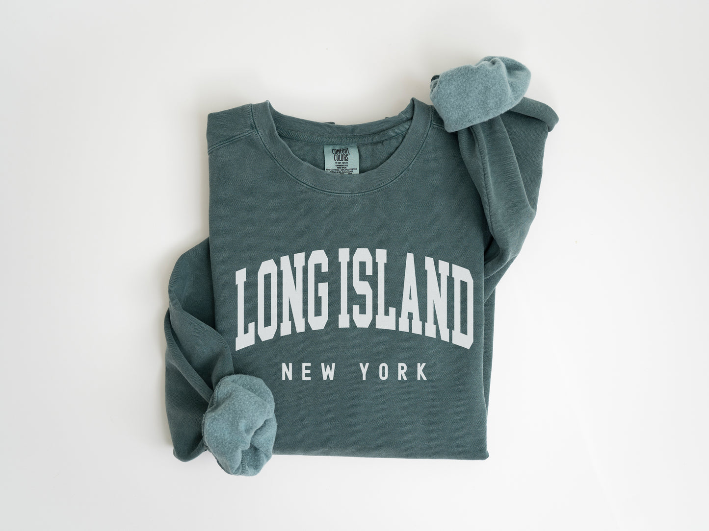 a long island new york sweatshirt laying on a white surface