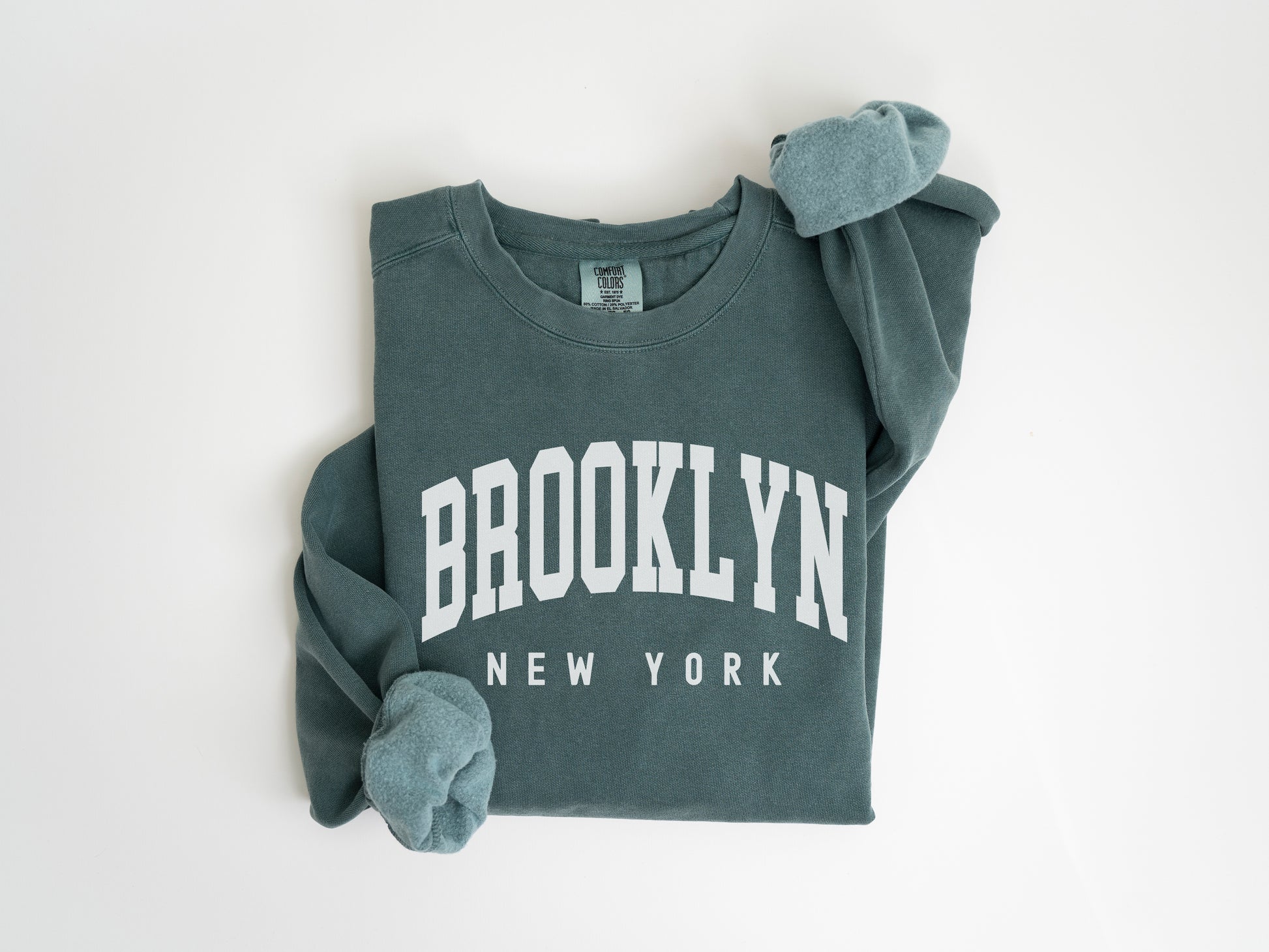 a green sweatshirt with brooklyn on the front and new york on the back