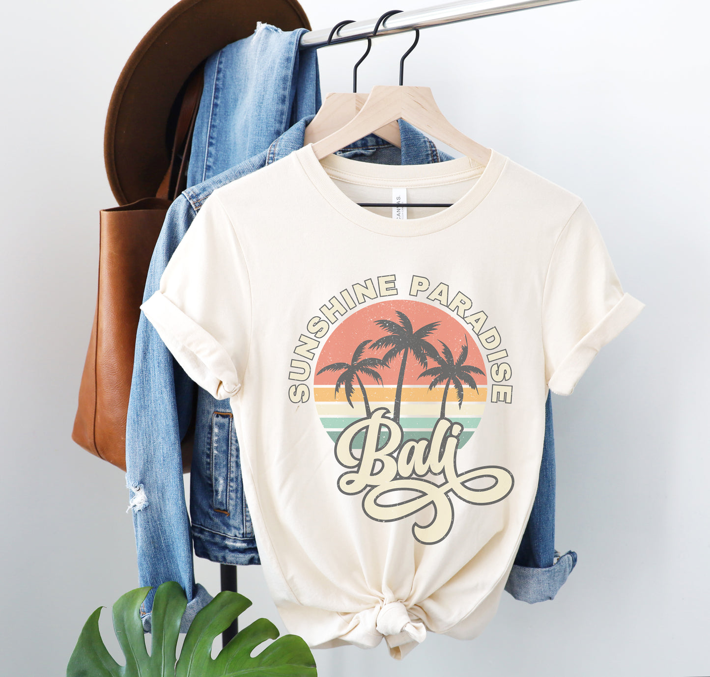 a t - shirt that says sunshine paradise on it hangs on a clothes rack