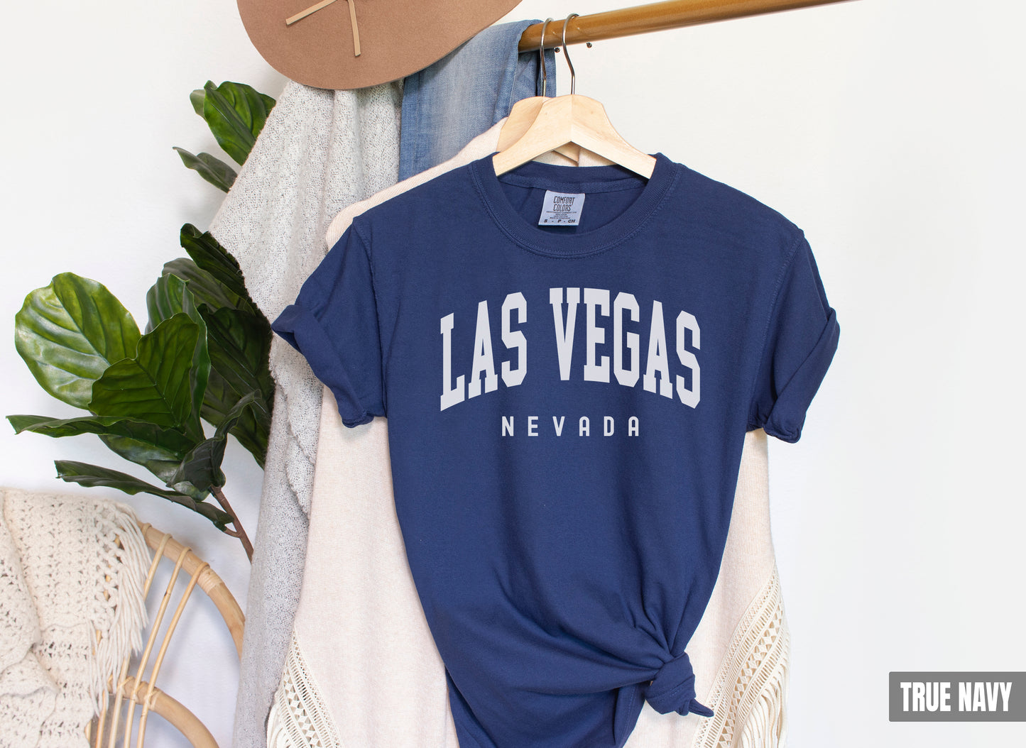 a t - shirt that says las vegas next to a hat