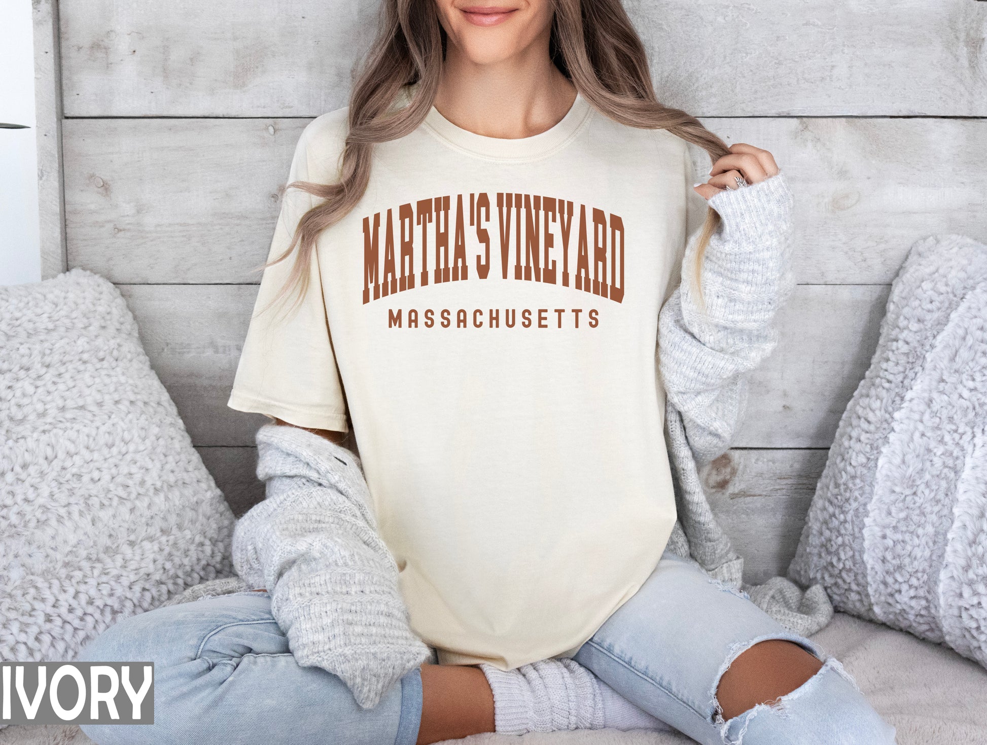 a woman sitting on a bed wearing a shirt that says martha's vineyard