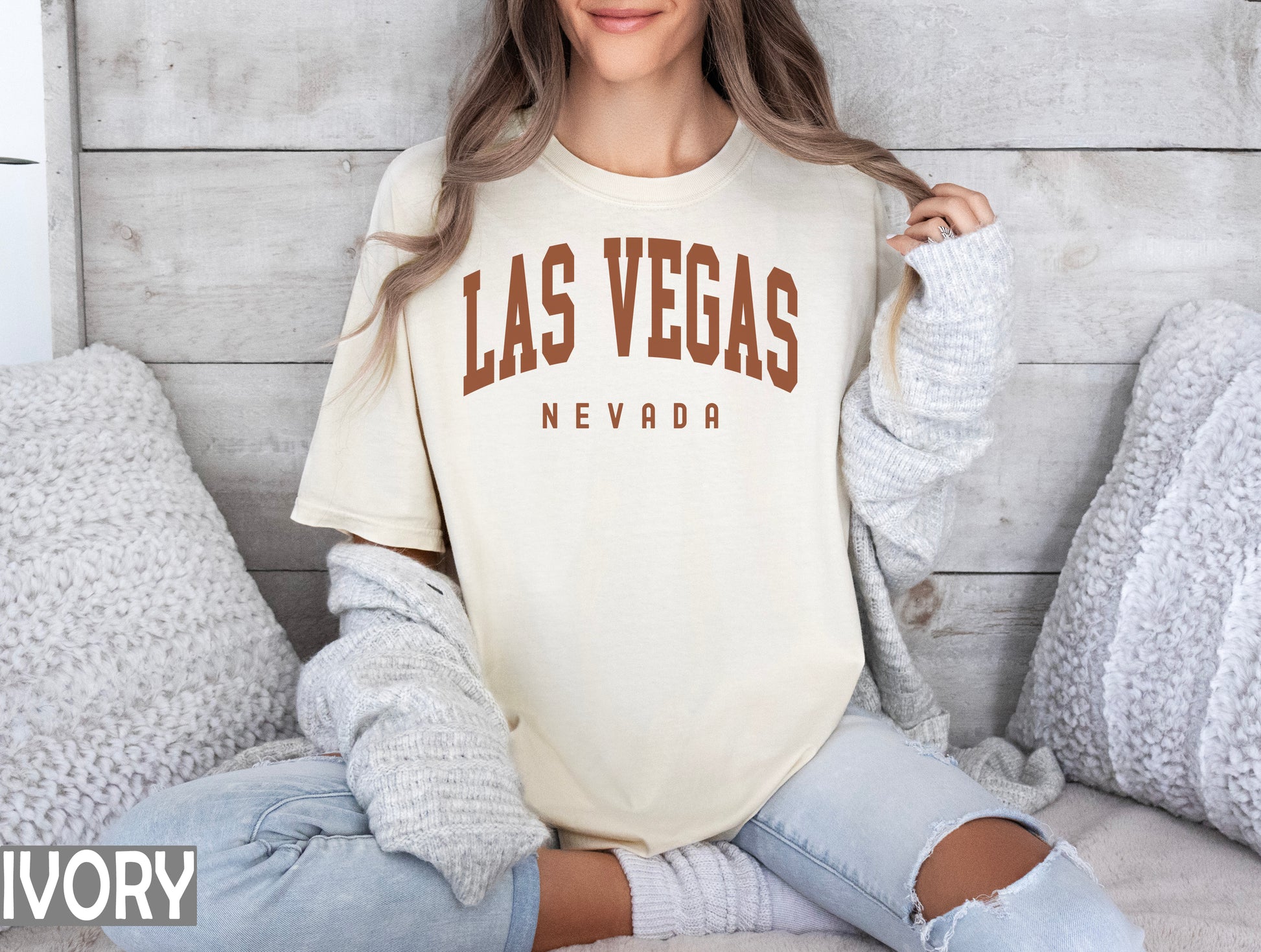 a woman sitting on a bed wearing a las vegas shirt