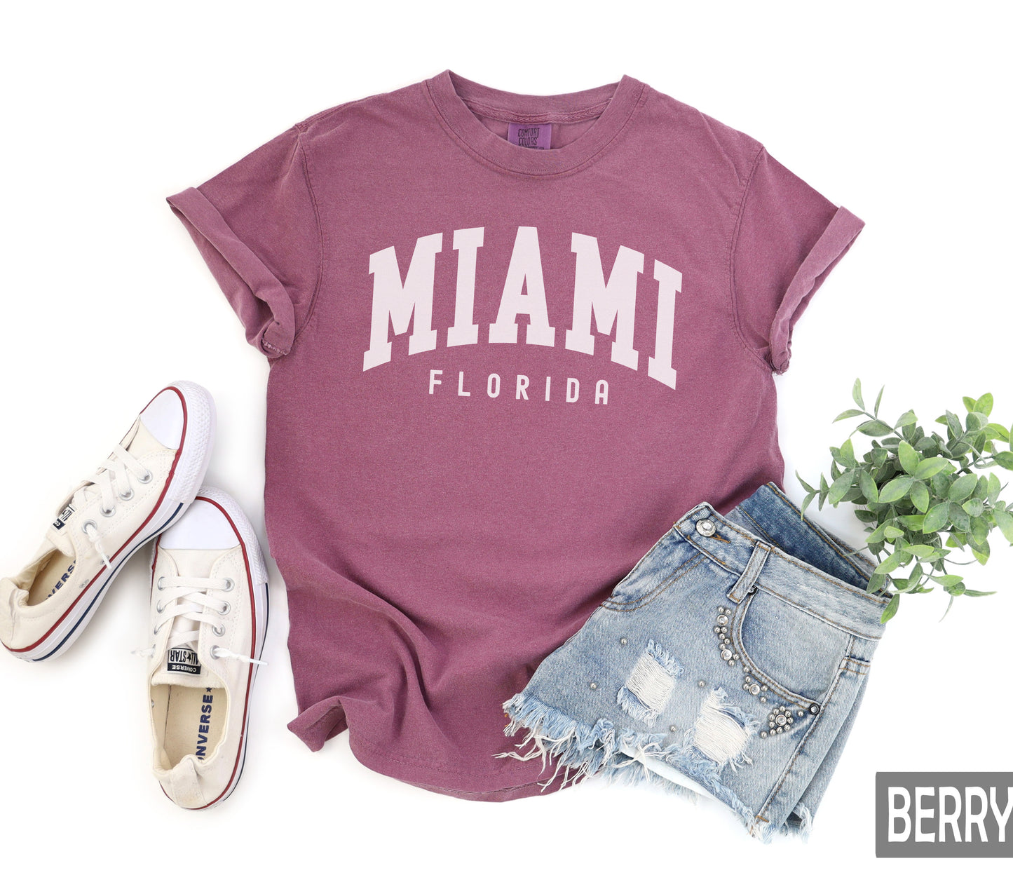 a t - shirt with the word miami on it next to a pair of shorts