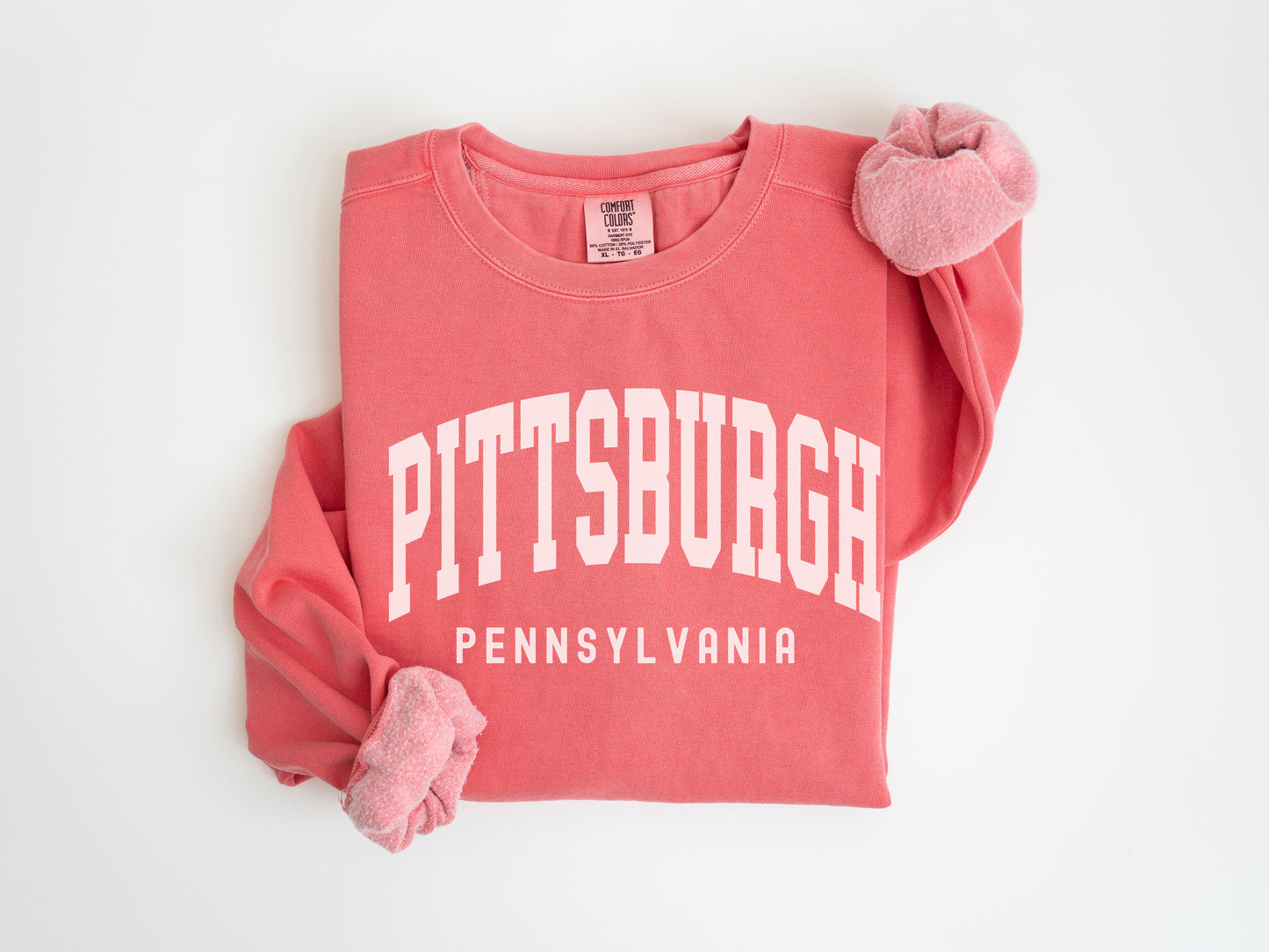 a pink sweatshirt with a pink pom pom on it