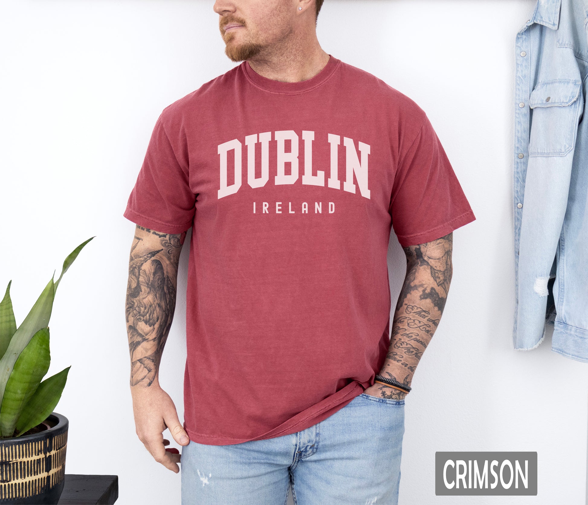 a man wearing a dublin t - shirt standing in front of a wall