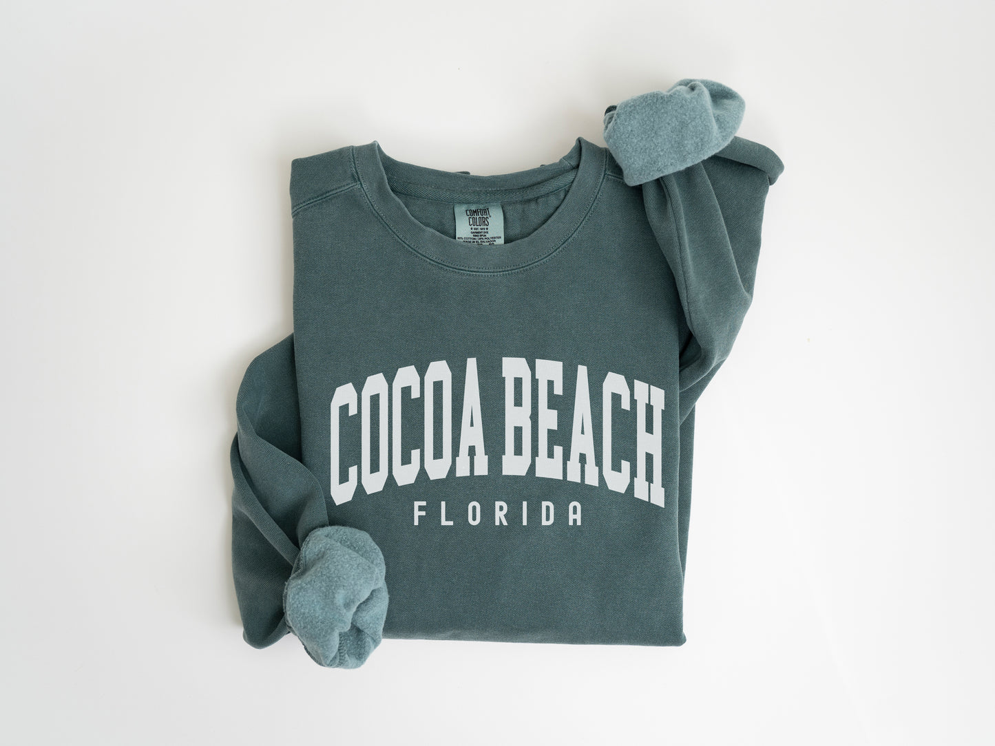 a green sweatshirt with the word cocoa beach on it