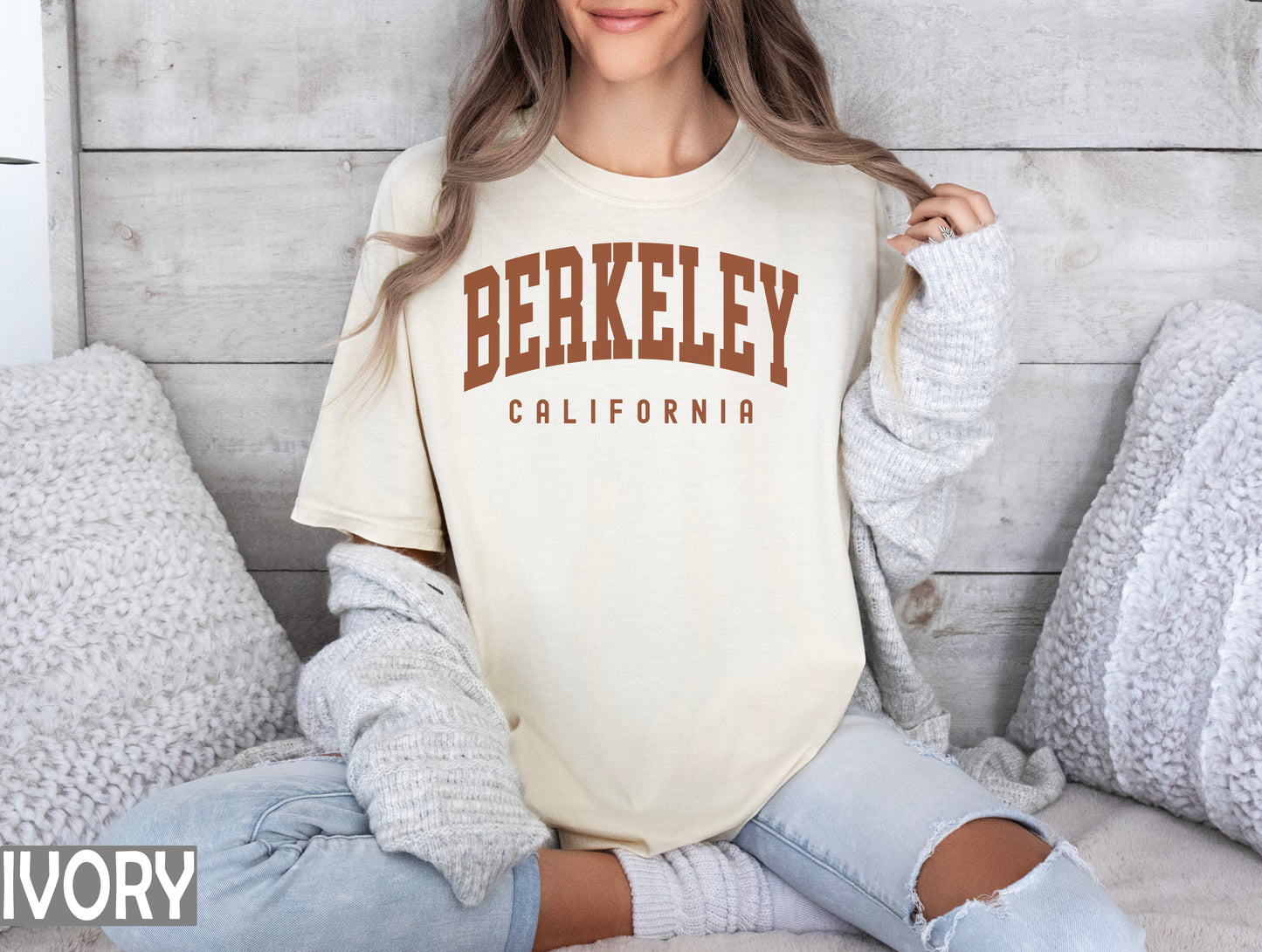 a woman sitting on a bed wearing a t - shirt that says berkley