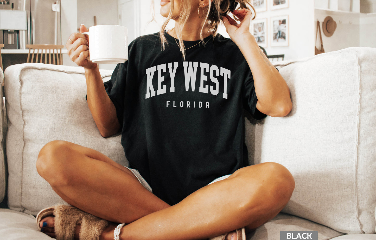 a woman sitting on a couch holding a cup of coffee