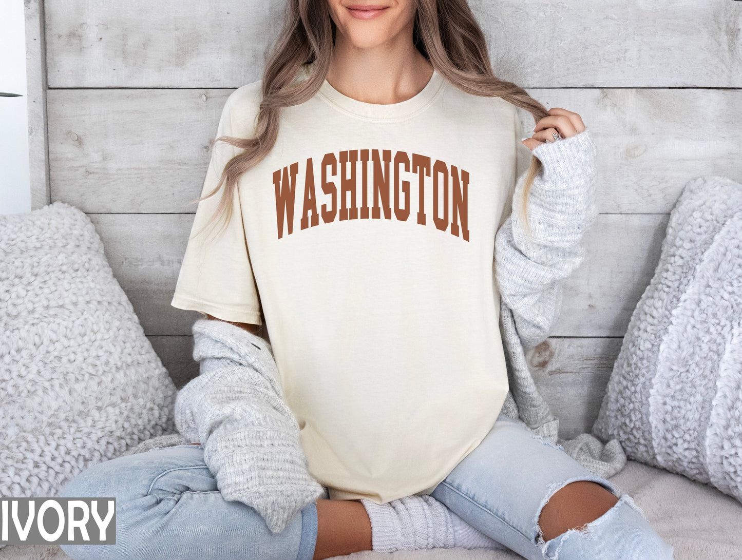 a woman sitting on a bed wearing a washington t - shirt