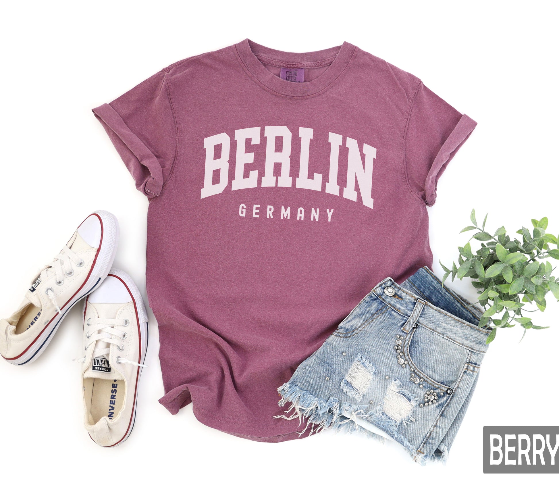 a t - shirt with the word berlin on it next to a pair of shorts