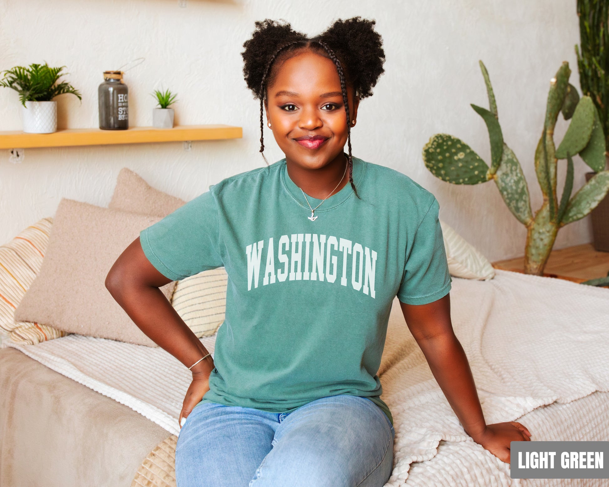 a woman sitting on top of a bed wearing a green shirt