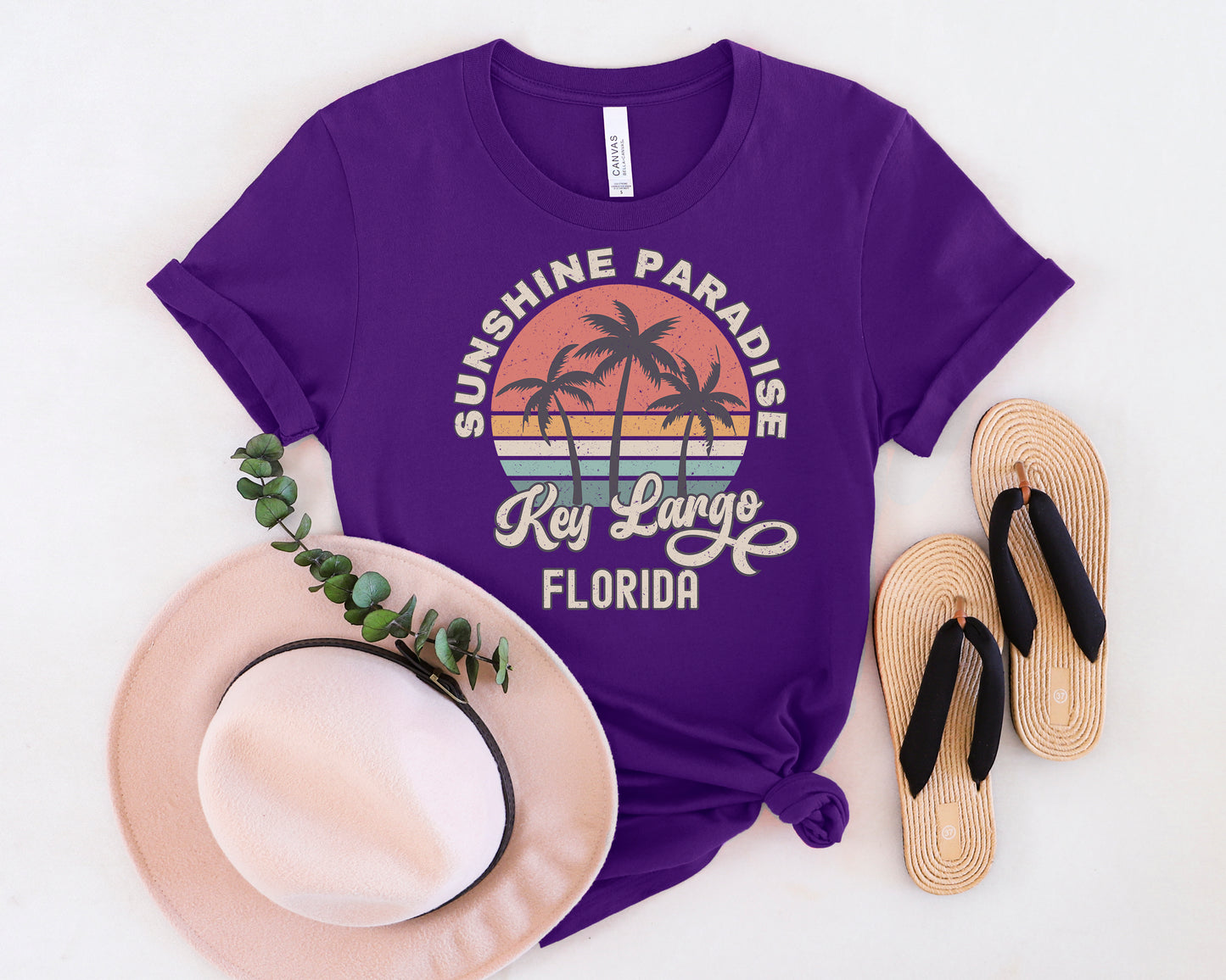 a purple shirt that says sunshine paradise, key largo, and a hat