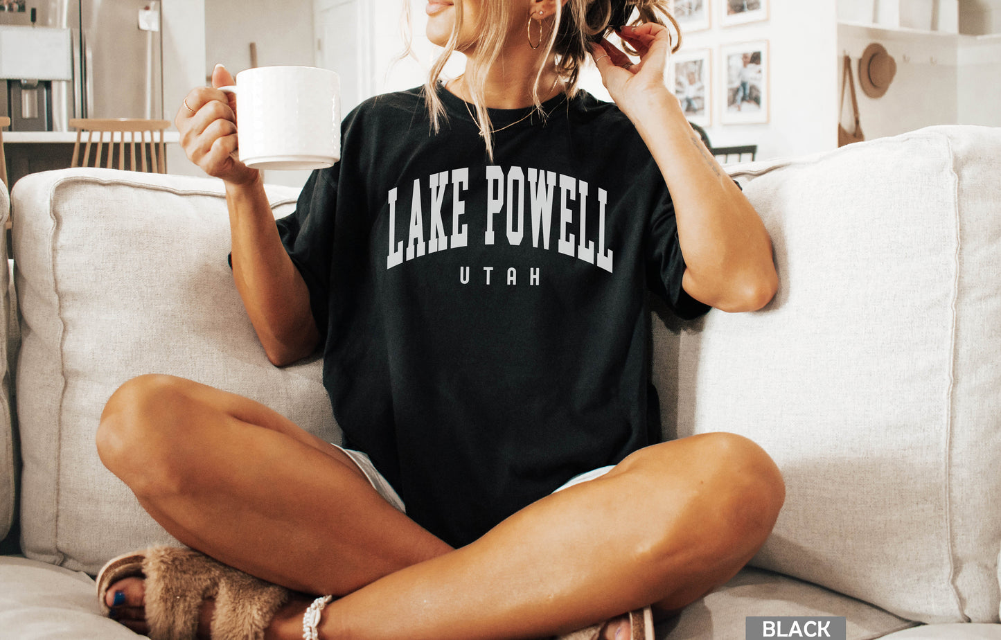 a woman sitting on a couch holding a cup of coffee