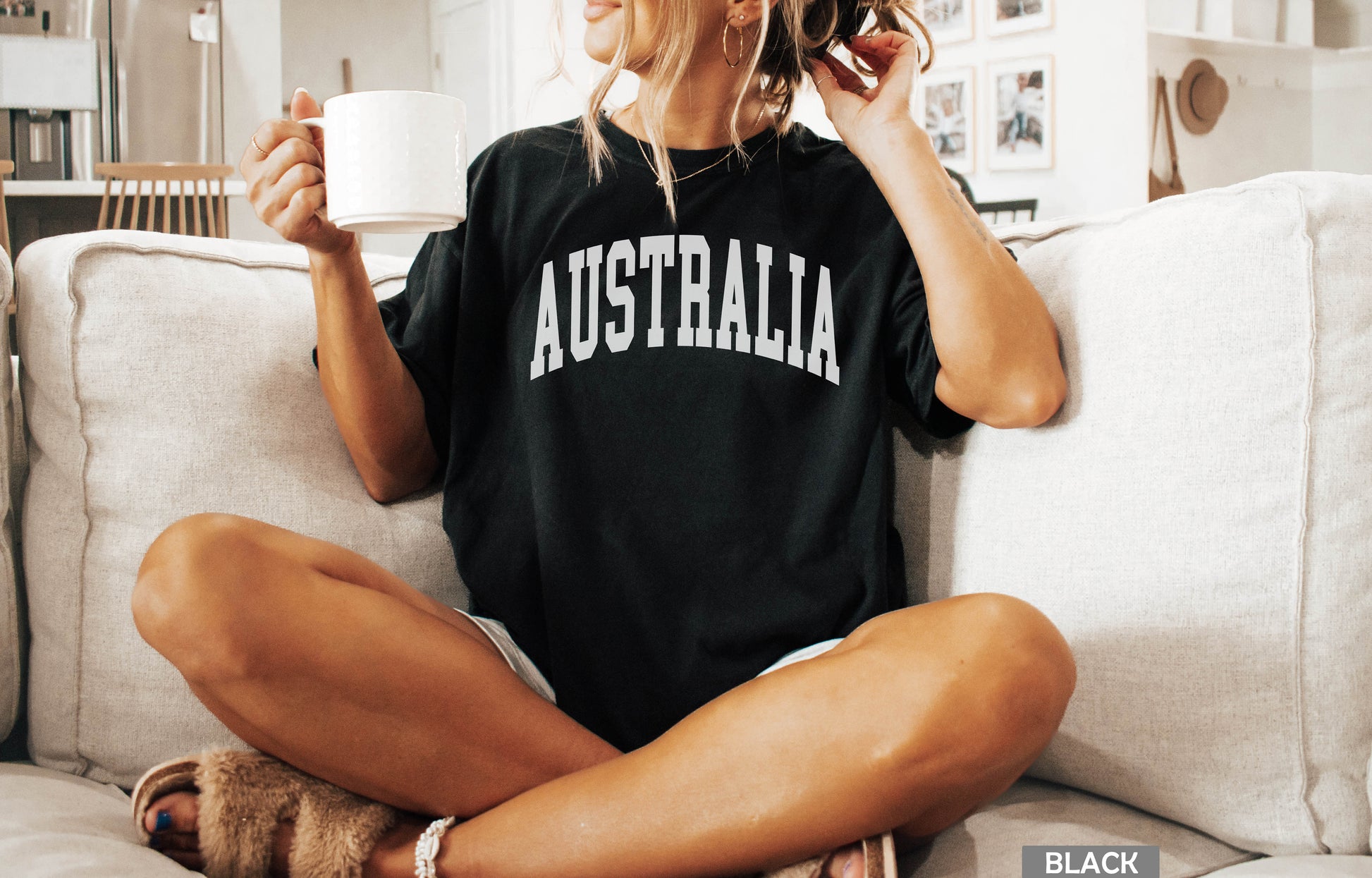 a woman sitting on a couch holding a cup of coffee