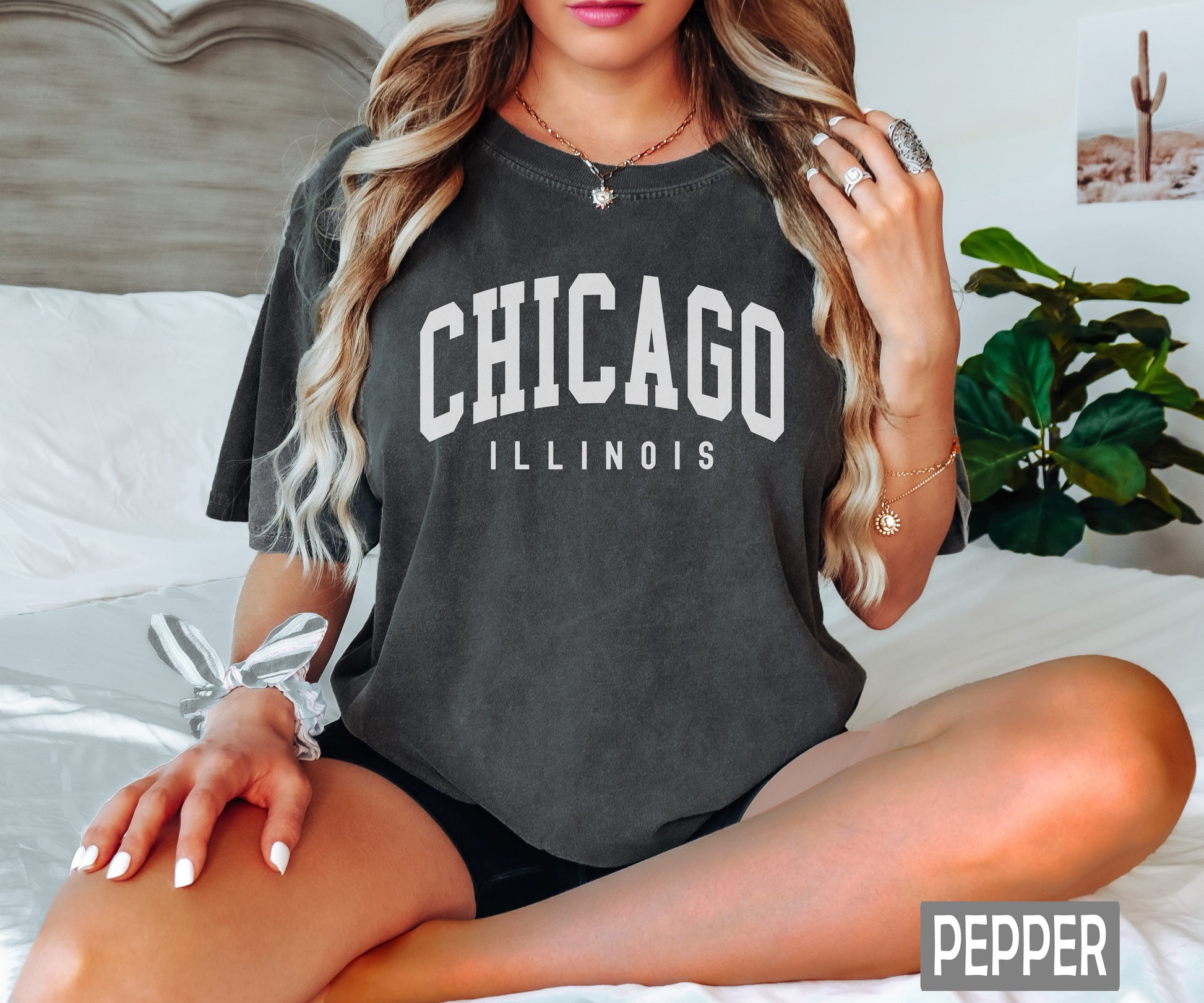 a woman sitting on a bed wearing a chicago illinois shirt