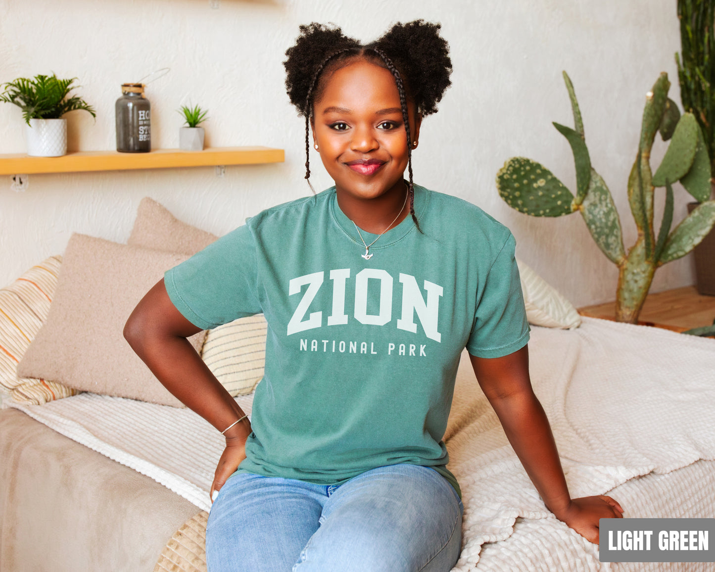 a woman sitting on top of a bed wearing a green shirt