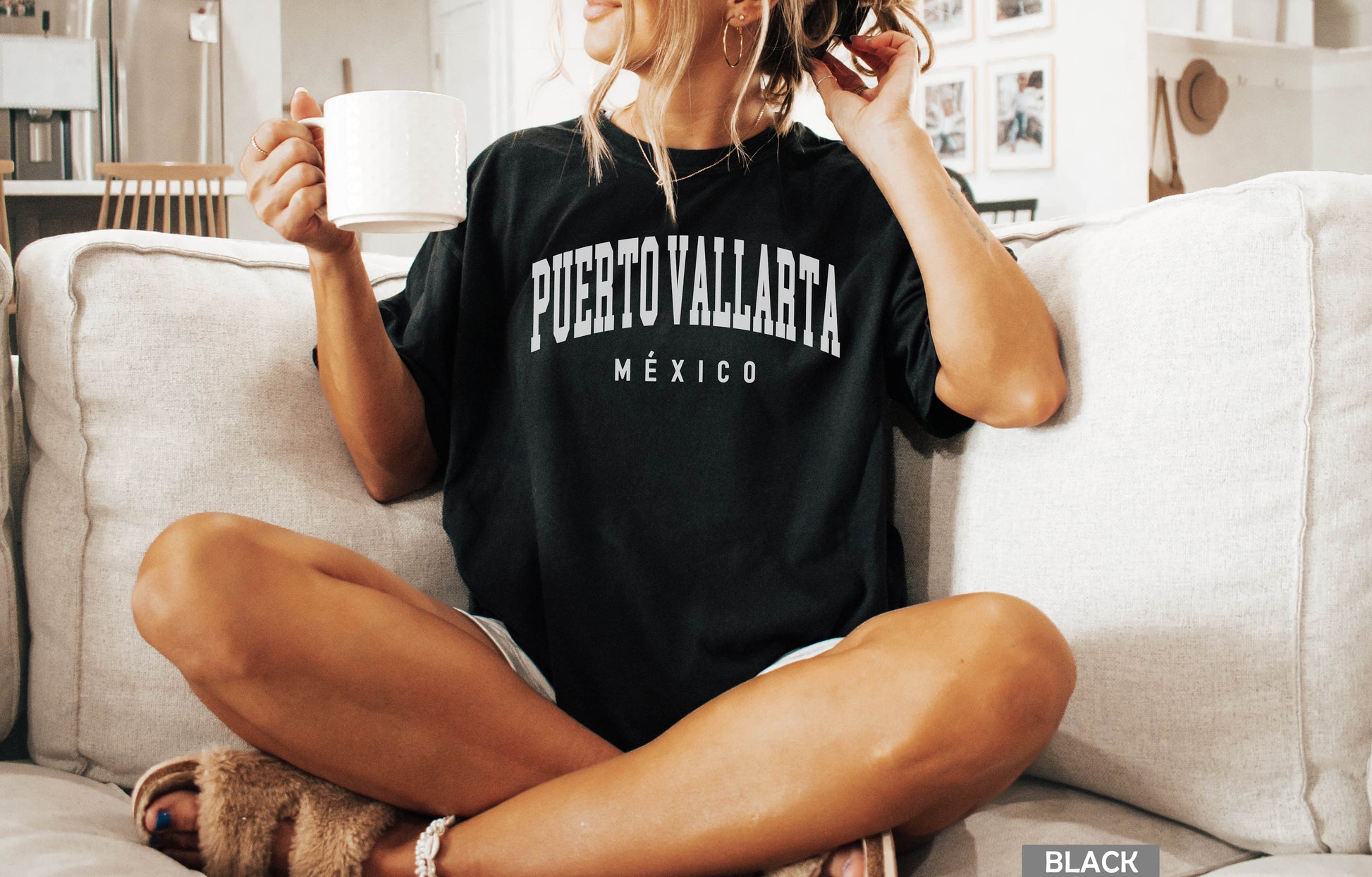 a woman sitting on a couch holding a cup of coffee