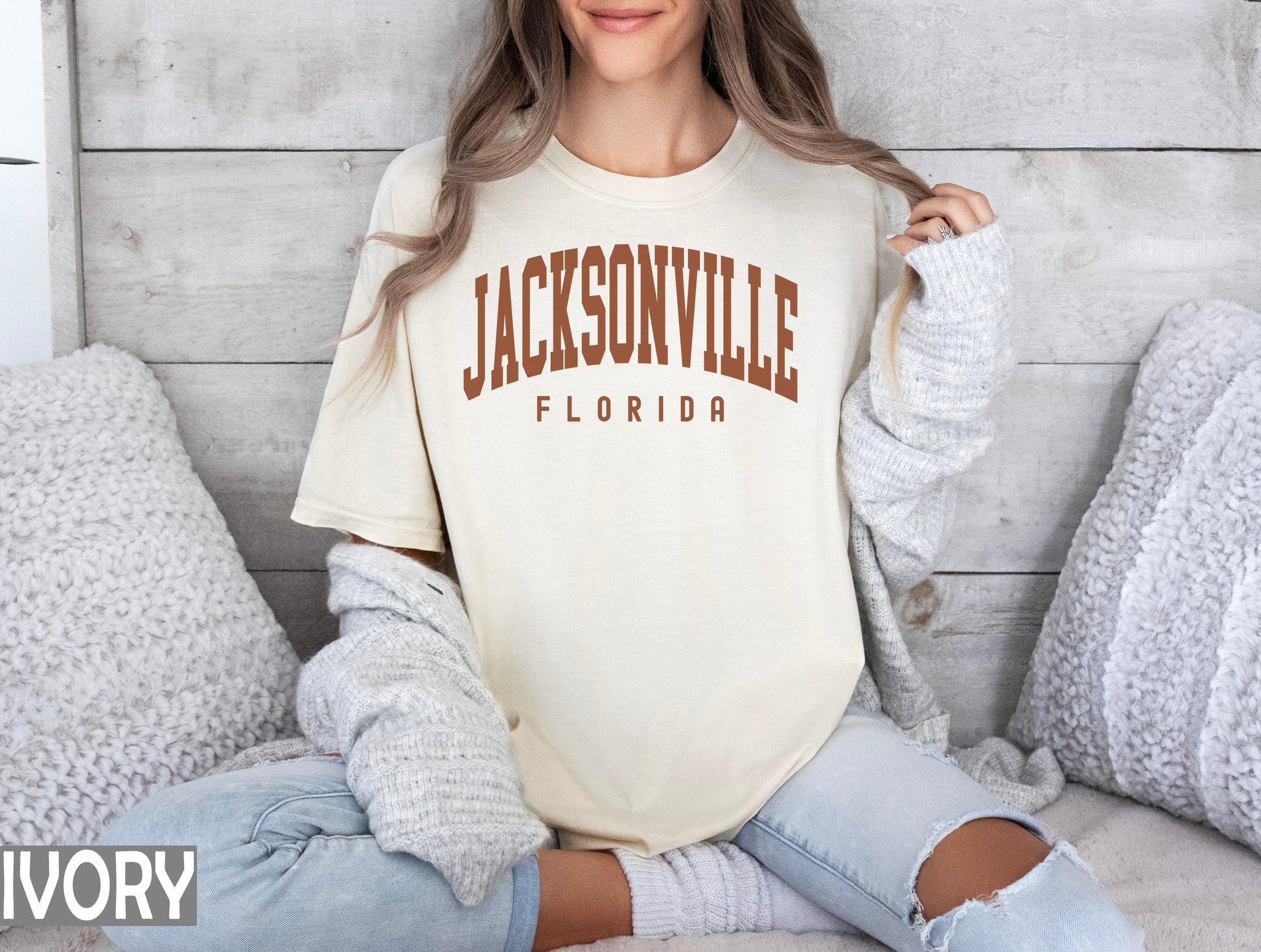 a woman sitting on a bed wearing a shirt that says jacksonville