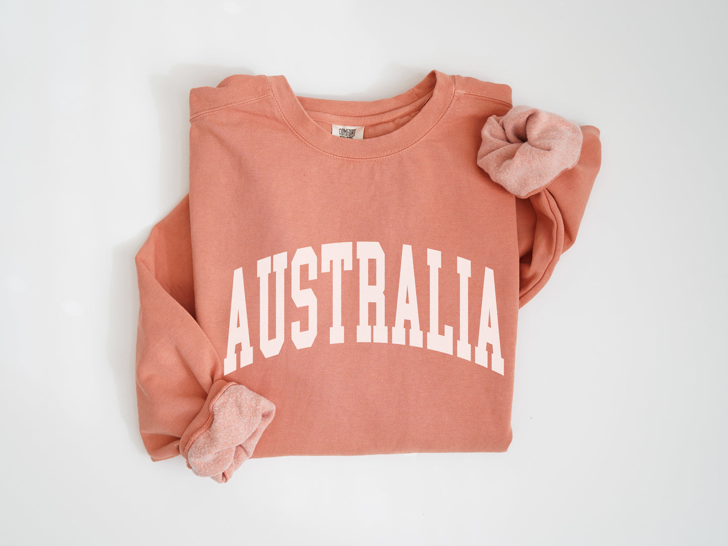 a pink sweatshirt with the word australia printed on it