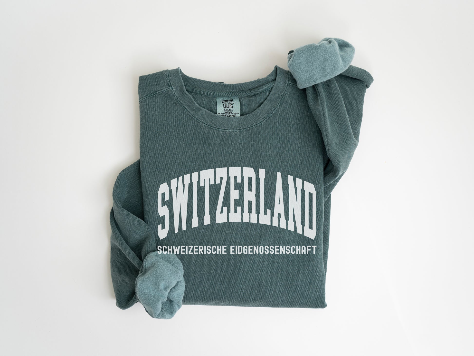 a green sweater with the word switzerland on it