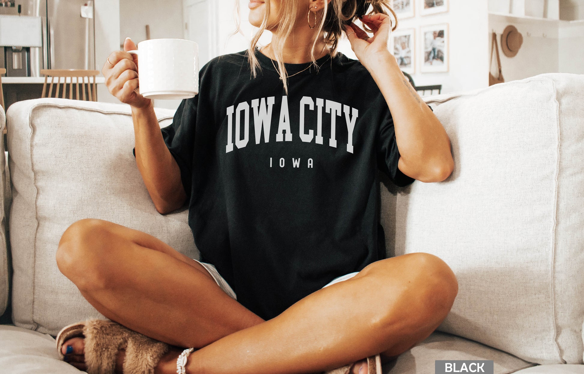 a woman sitting on a couch holding a cup of coffee