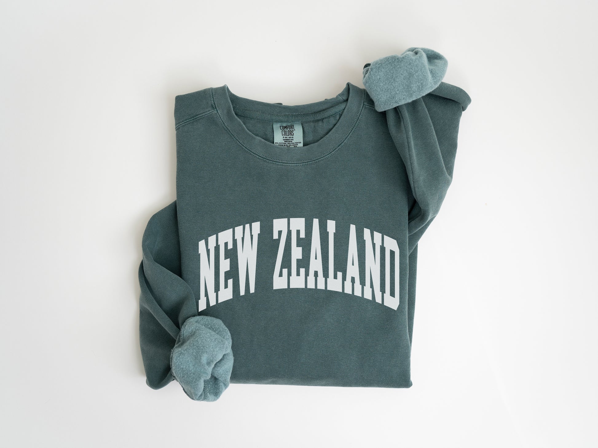 a green sweatshirt with the word new zealand printed on it